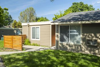 A small house with a yard and a wooden fence